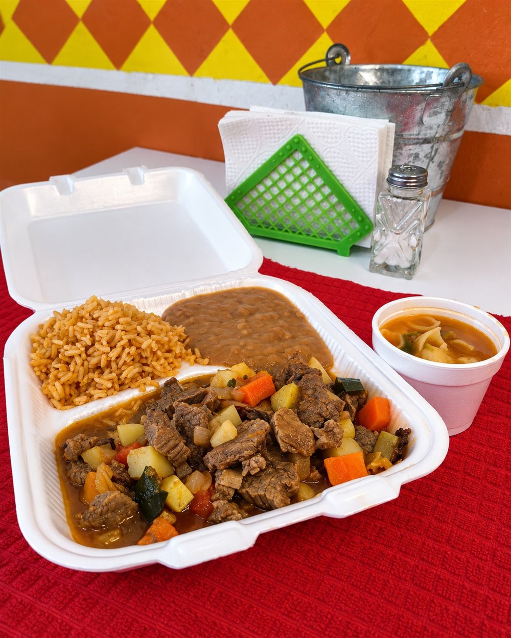 Carne de res guisada con verduras, arroz y frijoles